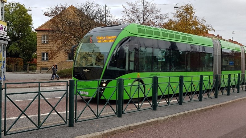 Bild på en grön BRT-buss i trafik.